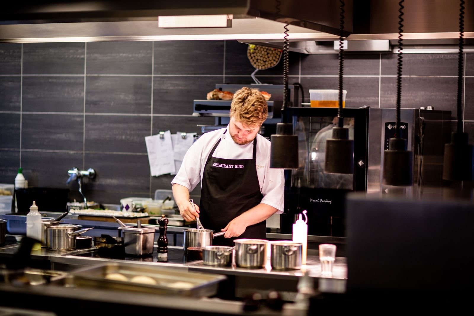 Commercial kitchen in operation with stainless steel equipment in place