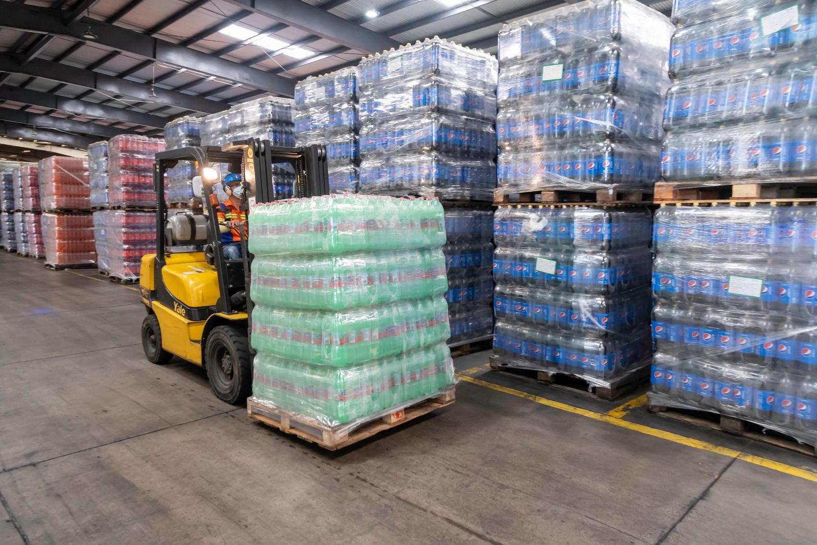 Forklift moving pallets inside a commercial warehouse